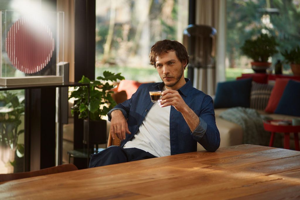 Mann trinkt Espresso in Café-Umgebung