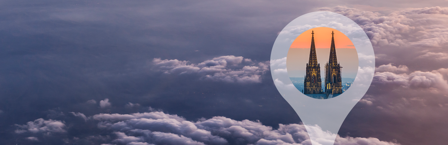 Über den Wolken als Hintergrund, vorne Positionsfähnchen mit Kölner Dom